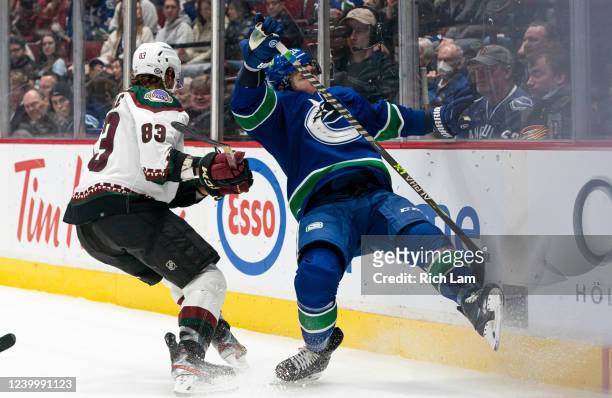 Jay Beagle of the Phoenix Coyotes upends Travis Dermott of the Vancouver Canucks while battling for the puck in the third period at Rogers Arena on...