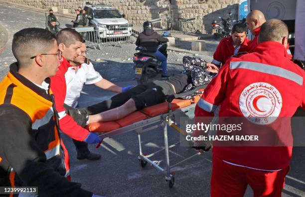 Rescuers in front of the Lion's gate evacuate an injured man as Palestinian demonstrators and Israeli police clash at Jerusalem's Al-Aqsa mosque...