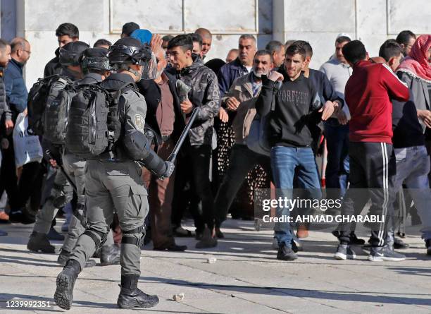 Palestinians are kept at bay by Israeli police during clashes at Jerusalem's Al-Aqsa mosque compound, on April 15, 2022. - Witnesses said that...