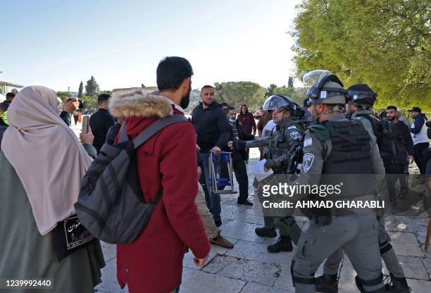 Palestinians are kept at bay by Israeli police during clashes at Jerusalem's Al-Aqsa mosque compound, on April 15, 2022. - Witnesses said that...