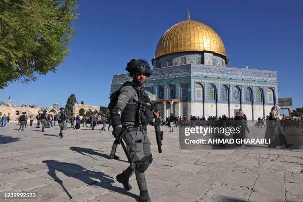 Palestinians are kept at bay by Israeli police during clashes at Jerusalem's Al-Aqsa mosque compound, on April 15, 2022. - Witnesses said that...