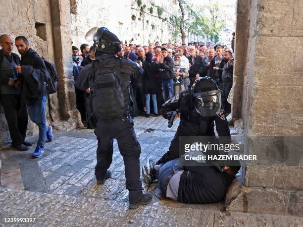 Israeli security forces immobilise a Palestinian man at an entrance to the al-Aqsa mosque compound as others are prevented from entering, on April...