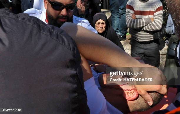 Rescuers evacuate a wounded protester from inside the al-Aqsa mosque compound during clashes with Israeli security forces, on April 15, 2022. - More...