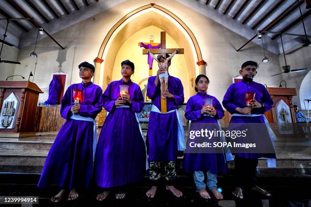 Christian youths and devotees seen carrying a cross as they take part in the religious procession during Good Friday at Prabhu Jishu Girja Church....