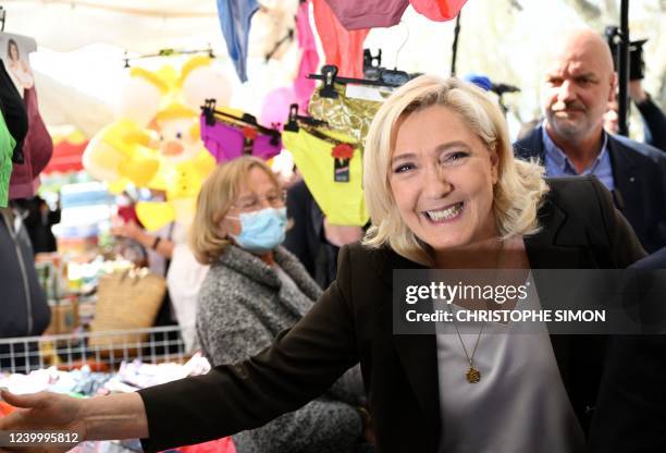 French far-right party Rassemblement National presidential candidate Marine Le Pen shakes hands with a supporter during a campaign visit at Pertuis'...