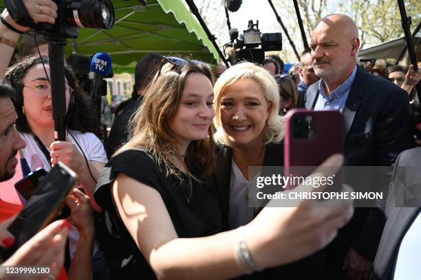 Supporter takes a selfie picture with French far-right party Rassemblement National presidential candidate Marine Le Pen during a campaign visit at...