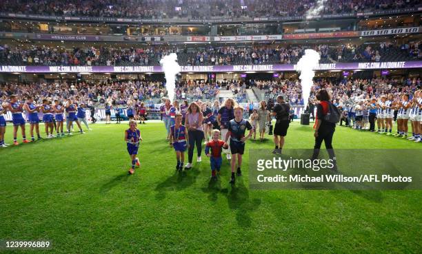 Royal Children Hospital patients and staff run onto the field during the 2022 AFL Round 05 match between the North Melbourne Kangaroos and the...