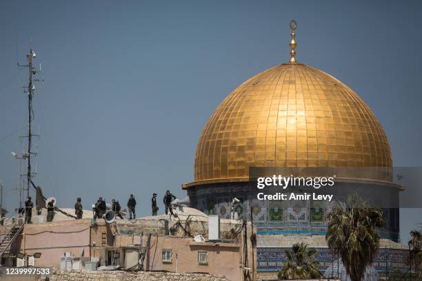 Israeli police officers stand on a roof top near Al-Aqsa Mosque following clashes with muslim prayers during the second Friday prayer of the Muslim...