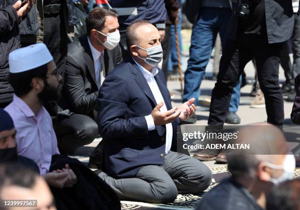 Turkish Foreign Minister Mevlut Cavusoglu performs the second Friday prayer of Islam's holy month of Ramadan in the courtyard of the Haci Bayram...