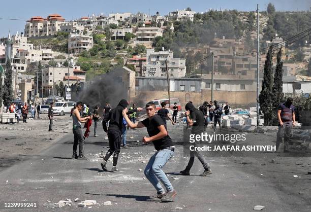 Palestinian protesters hurl rocks at Israeli security amid clashes during a demonstration against Jewish settlements and in support of Jerusalem's...
