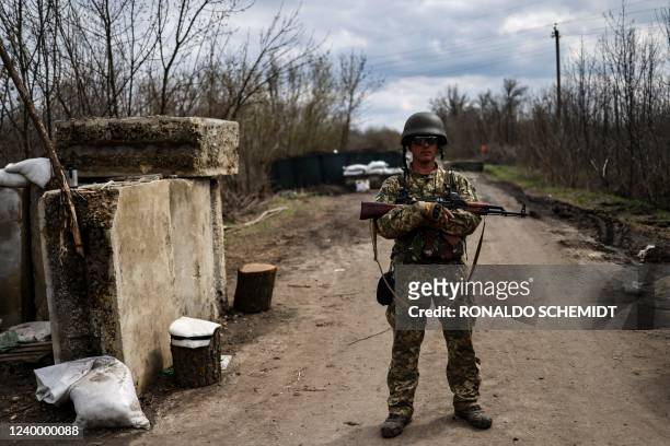 Ukrainian serviceman stands guard at a checkpoint on the outskirts of Barvinkove, eastern Ukraine, on April 15, 2022. - The Ukrainian presidency said...