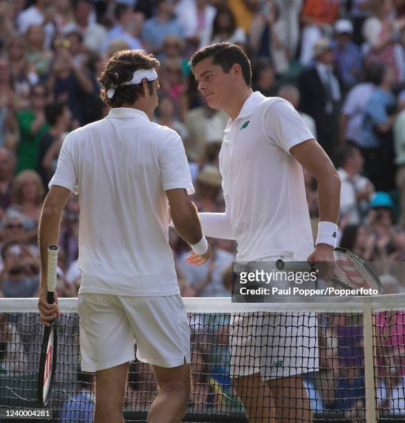 Roger Federer of Switzerland is congratulated by Milos Raonic of Canada after winning their men's singles semi-final on day eleven of the Wimbledon...