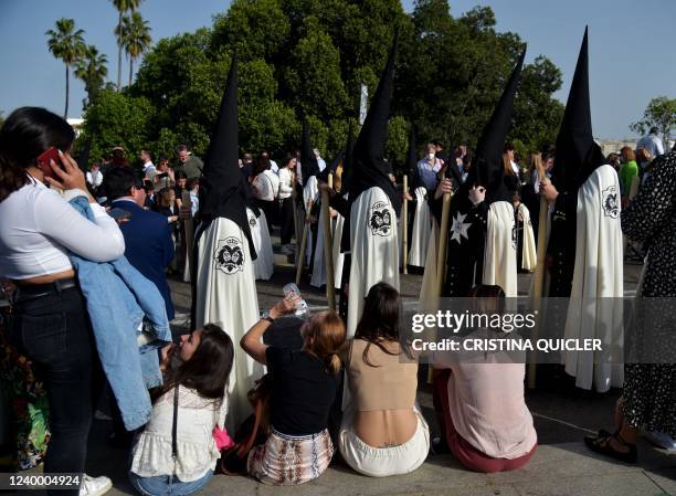 Woman drinks water as penitents of "El Cachorro" brotherhood take part in a Good Friday procession as part of the Holy Week, in Seville on April 15,...