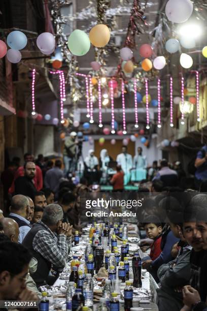 Hundreds of residents break their fast at the 70-meter iftar table during the holy month of Ramadan in the Mataria district of Cairo, Egypt on April...