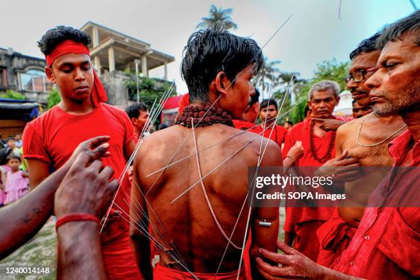 Hindu devotee is being pierced with sharp needles during Charak Puja Celebration. Charak Festival is one of the oldest Folk festivals as devotees...