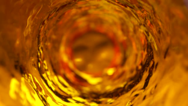 Beer with bubbles moves in a glass in slow motion. Abstract water background. Seamless loop 3d render
