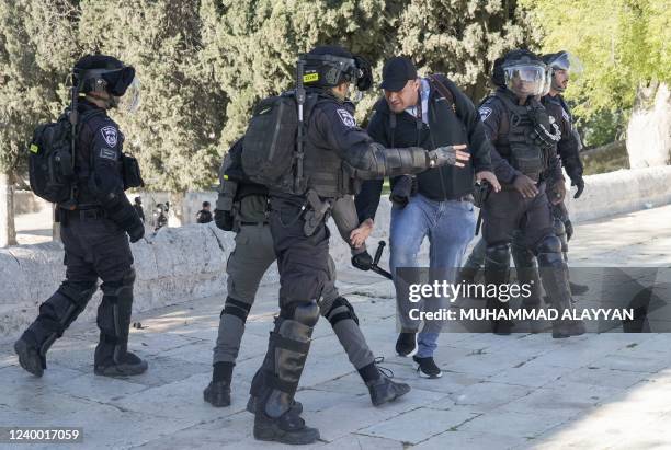 An Israeli security officer beats AFP photographer Ahmad Gharabli with a baton as he covers clashes with Palestinian protesters at Jerusalem's...