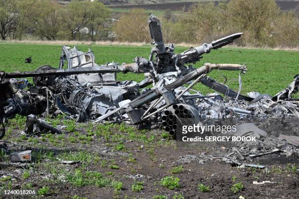 The wreckage of a downed Russian helicopter lies in a field near Kharkiv on April 16 amid the Russian invasion of Ukraine. - Russia has stepped up...