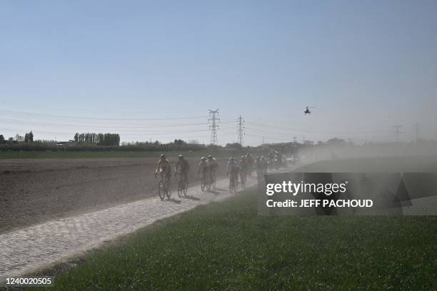 The pack ride the cobbles during the second edition of the Paris-Roubaix one-day classic cycling race, between Denain and Roubaix, on April 16, 2022.