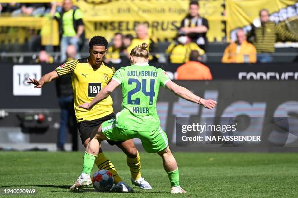 Dortmund's English midfielder Jude Bellingham and Wolfsburg's Austrian midfielder Xaver Schlager vie for the ball during the German first division...