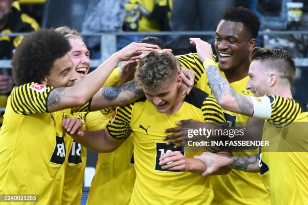 Dortmund's German defender Tom Alexander Rothe is celebrated by teammates for scoring the 1-0 during the German first division Bundesliga football...