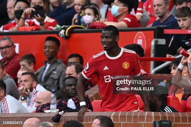 Manchester United's French midfielder Paul Pogba smiles as he takes his seat after being substituted during the English Premier League football match...