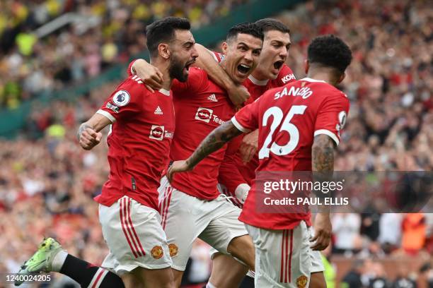 Manchester United's Portuguese striker Cristiano Ronaldo celebrates with teammates after scoring his third goal during the English Premier League...