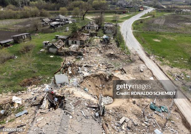 An aerial view shows a crater and destroyed homes in the village of Yatskivka, eastern Ukraine on April 16, 2022. - Russia's military focus now seems...