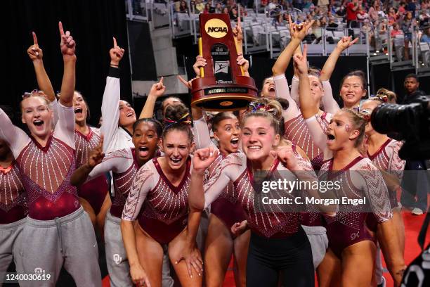 Olivia Trautman of the Oklahoma Sooners celebrates with the trophy after winning the Division I Womens Gymnastics Championship held at Dickies Arena...