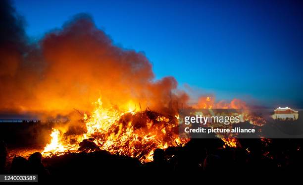 April 2022, Lower Saxony, Norderney: Numerous people stand in front of an Easter bonfire on the island's western beach on Holy Saturday. Photo:...