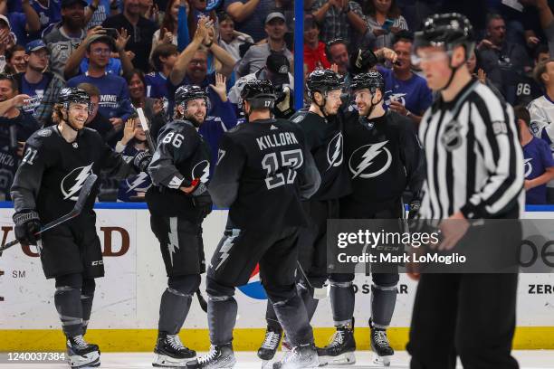 Mikhail Sergachev of the Tampa Bay Lightning celebrates a goal with teammates against the Winnipeg Jets during the third period at Amalie Arena on...