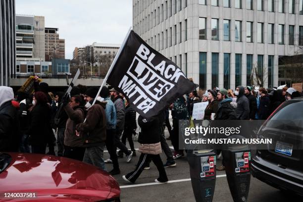 Protesters hold a Black Lives Matter flag as they march for Patrick Lyoya, a Black man who was fatally shot by a police officer, in downtown Grand...