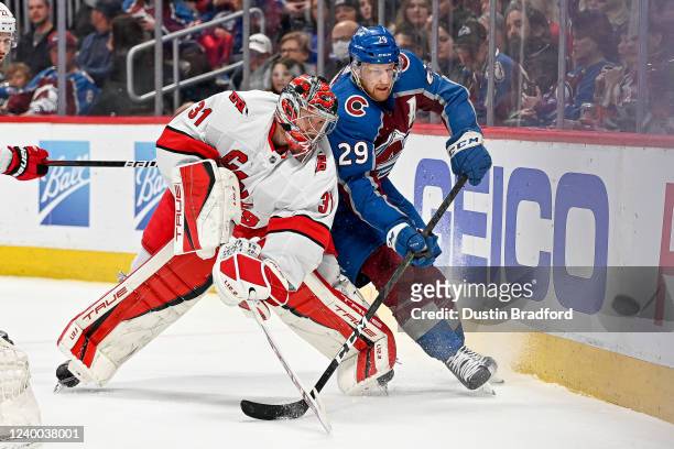 Frederik Andersen of the Carolina Hurricanes clears the puck as Nathan MacKinnon of the Colorado Avalanche skates on offense in the second period of...