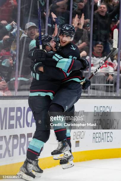 Matty Beniers of the Seattle Kraken celebrates with Jared McCann after scoring his first career NHL goal during the second period against the New...
