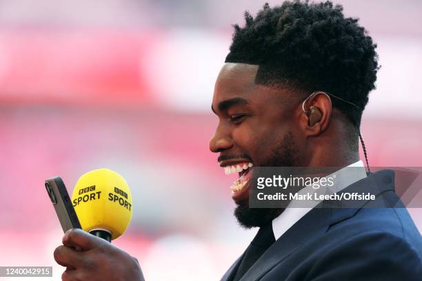 Micah Richards laughing as he looks at his mobile phone while working for BBC Sport during The Emirates FA Cup Semi-Final match between Manchester...
