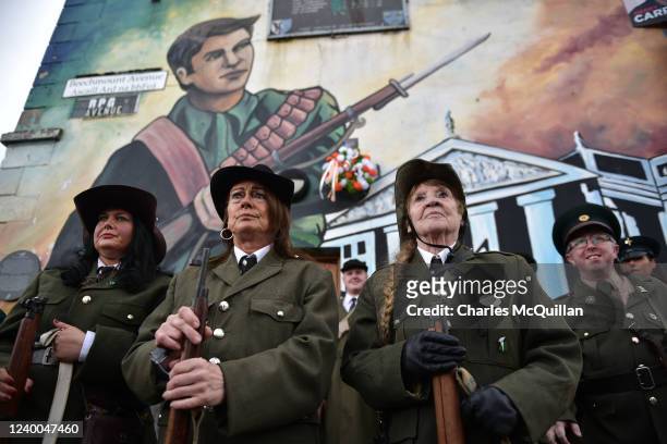 Irish Republicans dressed in costume stand in front of a 1916 rebellion mural as they commemorate the 1916 Easter Uprising on April 17, 2022 in...