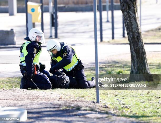 Police arrest a protester during rioting in Norrkoping, Sweden on April 17, 2022. - Plans by a far-right group to publicly burn copies of the Koran...