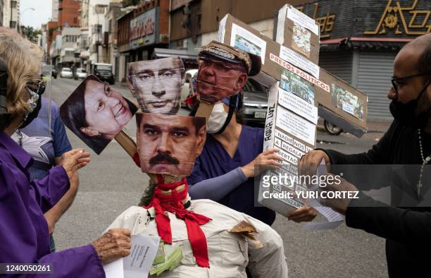 Opponents of the government of Venezuelan President Nicolas Maduro prepare to burn a dummy with the images of Maduro , Russian President Vladimir...