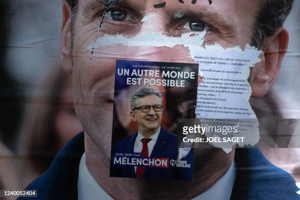 This picture taken on April 17, 2022 in Paris shows a campaign poster of France's President and La Republique en Marche party candidate Emmanuel...