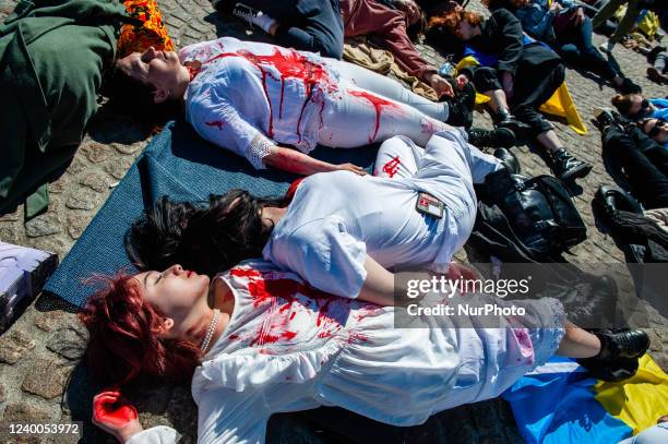 Group of Ukrainian women covered in fake blood lie on the ground in front of the Dam square in Amsterdam, to protest Russias war in Ukraine, on April...