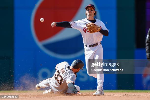 Ernie Clement of the Cleveland Guardians forces out Darin Ruf of the San Francisco Giants at second base and throws out Joc Pederson at first base to...