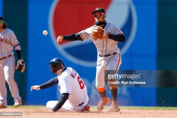 Thairo Estrada of the San Francisco Giants forces out Owen Miller of the Cleveland Guardians at second base and throws out Franmil Reyes at first...