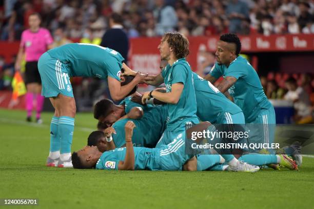 Real Madrid's players celebrate after French forward Karim Benzema scored a goal during the Spanish League football match between Sevilla FC and Real...