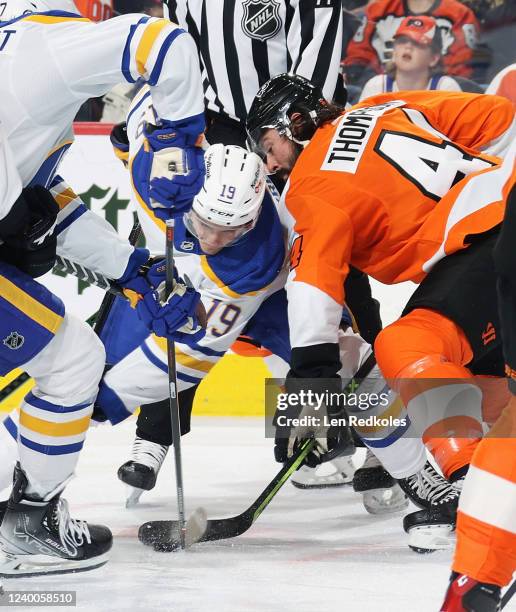 Nate Thompson of the Philadelphia Flyers battles for the loose puck after facing off with Peyton Krebs of the Buffalo Sabres at the Wells Fargo...