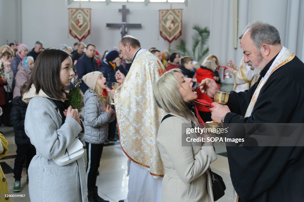 Ukrainian believers receive holy communion as they celebrate...