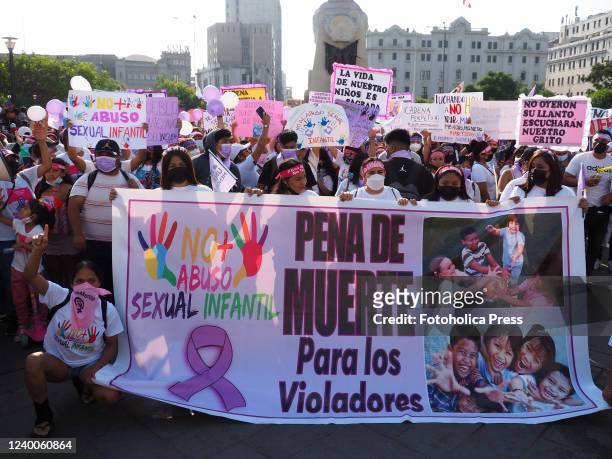 Death penalty for rapists" can be read on a banner when feminists and hundreds of people, mostly women, march through the Lima downtown demanding...