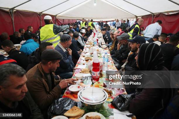 Algerian volunteers take part in the service of preparing and serving free iftar, the meal that Muslims eat after sunset during the month of Ramadan...