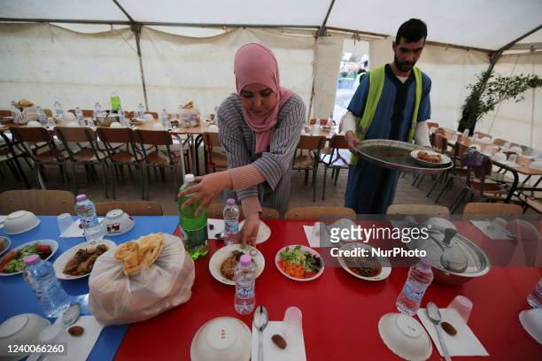 Algerian volunteers take part in the service of preparing and serving free iftar, the meal that Muslims eat after sunset during the month of Ramadan...