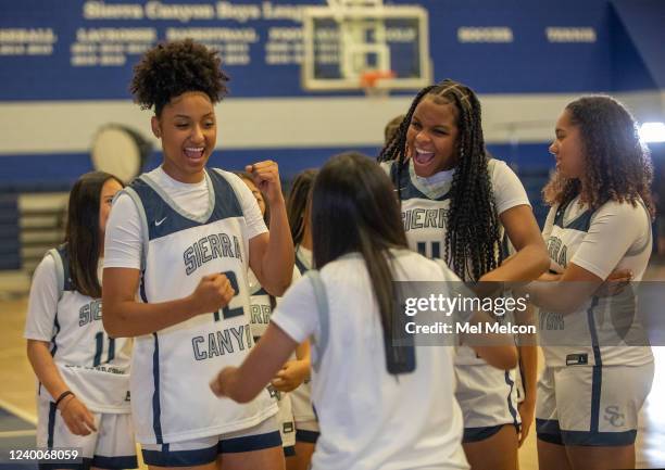 Juju Watkins, foreground, left and Mac Randolph, 2nd from right, members of the Sierra Canyon girls basketball team, share a light moment with...