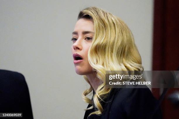 Actress Amber Heard listens in the courtroom at the Fairfax County Circuit Court in Fairfax, Virginia on April 18, 2022. - Depp sued his ex-wife...